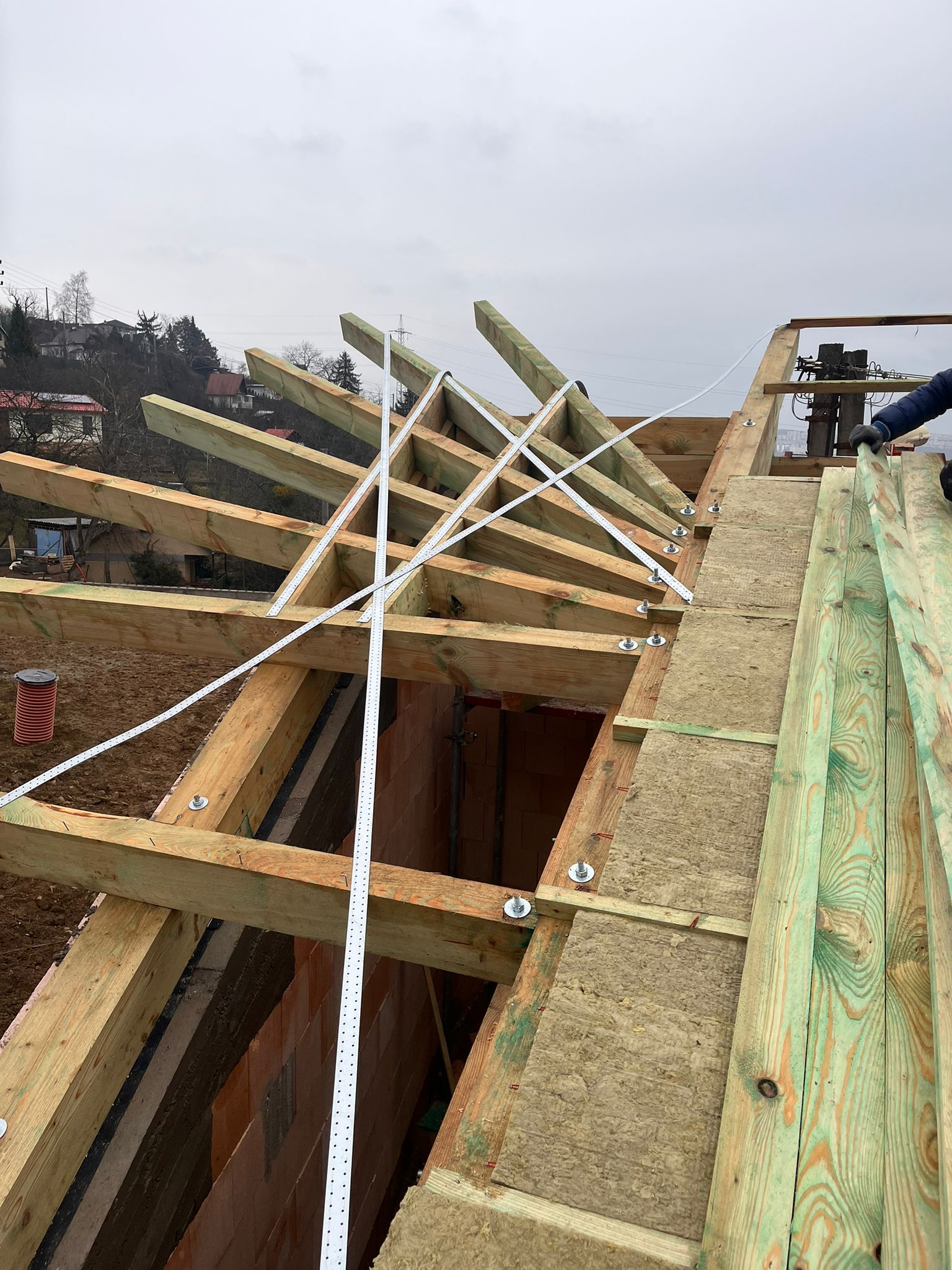 Detail strešnej konštrukcie s drevenými trámami a kovovými spojovacími prvkami